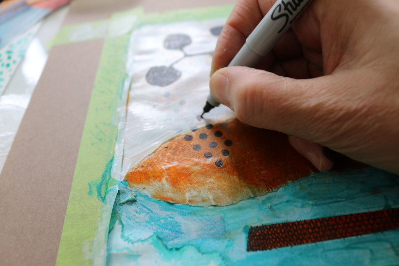 Here I am using a marker to go over the stamped design that lost its visibility underneath the layers of paint.